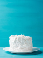 White creamy cake on the blue wooden background