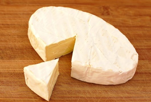 Cheese camembert on the brown wooden background
