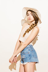 Fashion woman in crochet crop top, hat and denim shorts