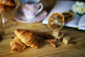 cup with tea croissant book
