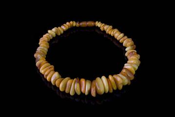Beautiful necklace made of amber, natural stone, yellow on a black background, glass.