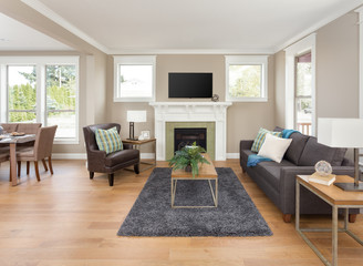 Beautiful living room interior with hardwood floors and fireplace in new home with view of dining room