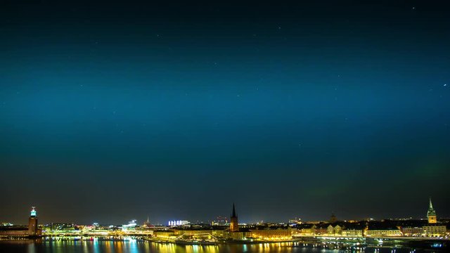 Northern Lights in full display over the bay Riddarfjarden in central Stockholm, Sweden showing the City Hall to the left.