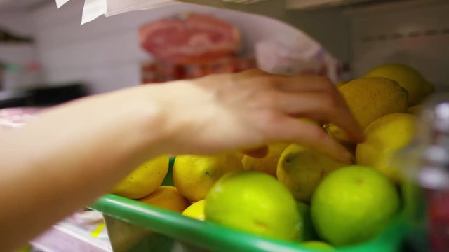  Hand of a young woman squeezing fruit before she buys at the grocery store