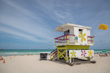 Miami Beach, Florida - May 9th 2014 - Tourists and locals enjoying a sunny day at Miami beach. Green water and blue sky. Miami, Florida, USA.
