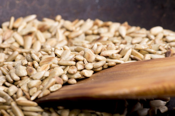 sunflower seeds, roasted sunflower seeds in a frying pan with a wooden spatula.