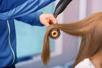 Naklejka premium woman feel relaxes drying stylist is drying her hair selective focus on hand of stylist