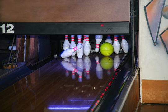 A bowling ball slams into the pins