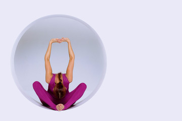 sporty woman  in  active wear, practicing  yoga exercises in geometric  design of round shapes,in sphere.
Studio shot, white background. Creative concept sports.
