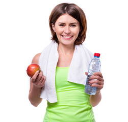 sport girl holding apple and water with towel on her neck isolated on white background