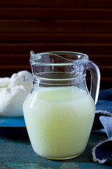 Milk whey and cottage cheese on a vintage wooden background.