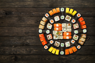 Set of sushi maki and rolls at black rustic wood.