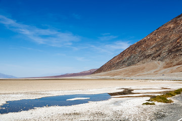 Beautiful scenario, sand formations in the foreground, blue sky day at the Death Valley National Park, Arizona, USA