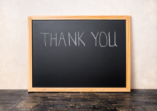 handwriting text thank you is written in chalkboard on craquelur