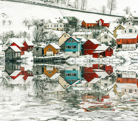 wooden houses on the banks of the Norwegian fjord with reflection in water