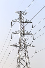 High voltage poles on sky background in rural areas.