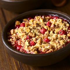 Johannisbeeren Crumble oder Crisp, ein gebackener Johannisbeeren Dessert mit Haferflocken und Walnuss Streusel, fotografiert mit natürlichem Licht (Selectiver Fockus, Fokus in die Mitte des Bildes)  