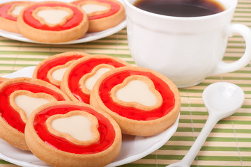 cookies with jelly and cup of coffee on bamboo napkin