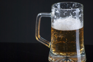 Beer glass with background and shinny reflection on bottom with beer falling into glass