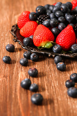 blueberries and strawberries on a plate stone background