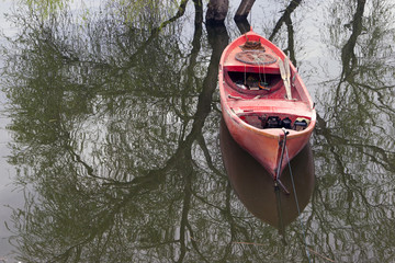 red fishing bot and tree reflections