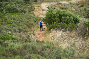 Naklejka premium Sporty woman running downhill