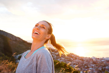 Fototapeta na wymiar Attractive older woman laughing outdoors during sunset