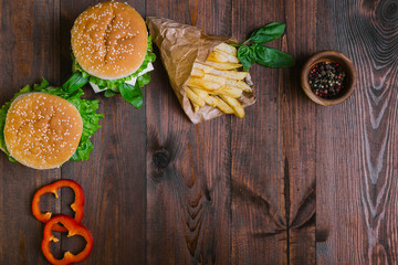 Burger with cheese and salad and fries potato on wooden board