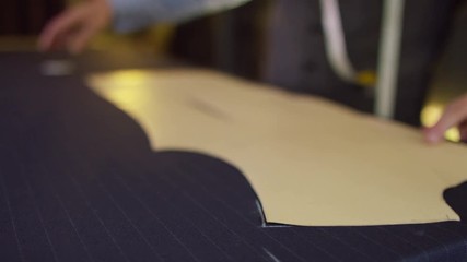  Tailor working in his shop, drawing templates on a piece of fabric. Shot on RED Epic.