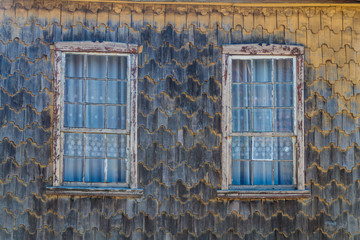 Fototapeta na wymiar Window of a wooden house in Curaco de Velez village, Quinchao island, Chile