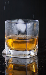 Whiskey Glass - Scotch Glass with ice cubes with background and shinny reflection on bottom