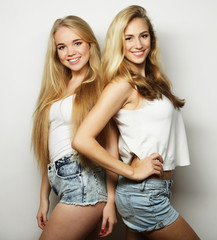 Two young girl friends standing together and having fun