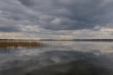 dark clouds in the stormy sky reflecting on the surface of calm forest lake
Absterna lake, Braslaw, Belarus