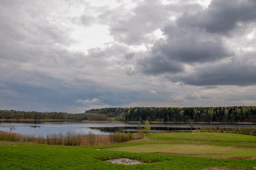 green fields and wooded hills surrounding forest lake
Ilmenek lake, Braslaw, Belarus
