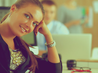 Young woman working in office, sitting at desk