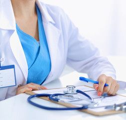 Portrait of young female doctor sitting at desk in hospital