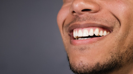 Healthy teeth of a male as he smiles at something, space for text