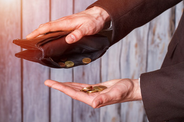 Hands holding coins and wallet. Black wallet and small coins. Not a cent more. The definition of...