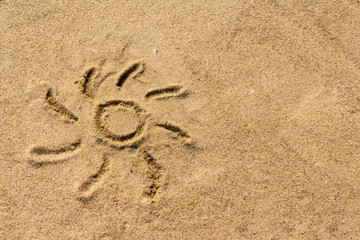 Sun drawn on the sand of the sea