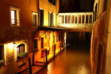Fototapeta na wymiar Kanal mit Brücke und Anlegestelle im nächtlichen Venedig