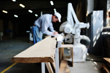 Carpenter makes marks on the wooden beams.