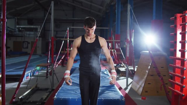  Professional male gymnast training on horizontal bar at the gym