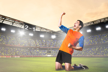 soccer or football player is celebrating goal on stadium