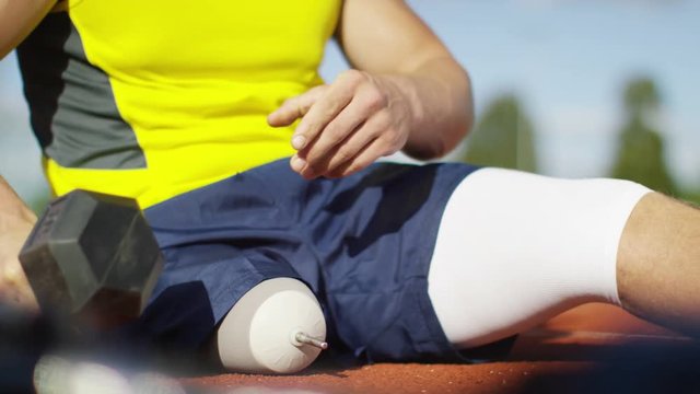  Disabled athlete with prosthetic leg working out with weights @ running track