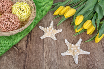 Starfishes and tulips on a wooden background