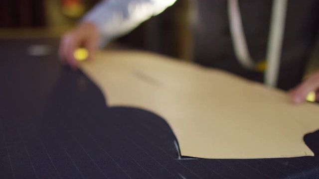  Tailor working in his shop, drawing templates on a piece of fabric. Shot on RED Epic.
