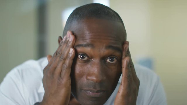  Close up portrait man in bathroom going through skin care routine 