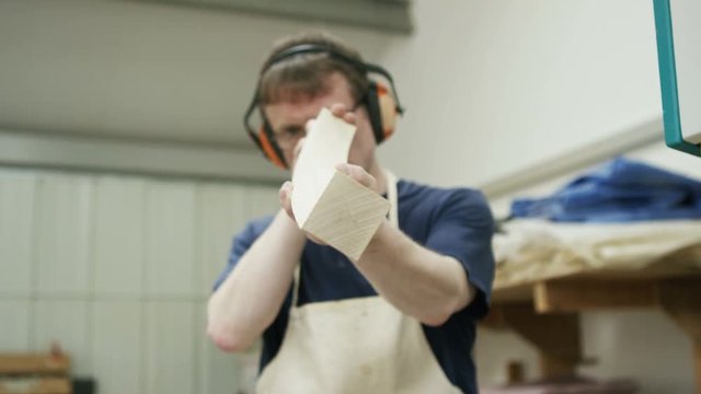  Furniture maker in his workshop, checking the quality of his work