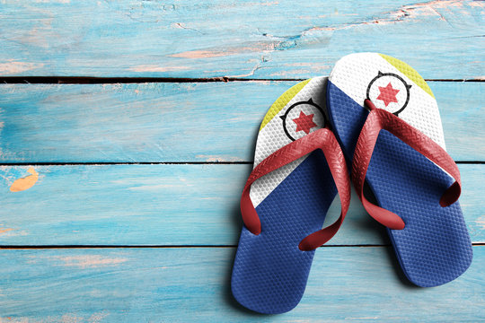Thongs with flag of Bonaire, on blue wooden boards