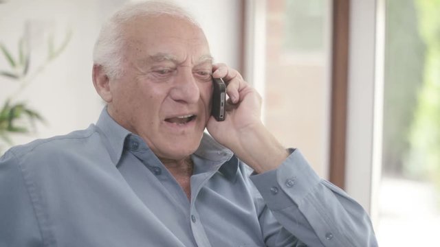  Elderly man in a wheelchair talking on mobile phone